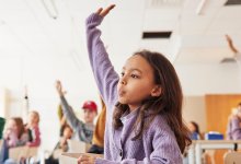 Photo of elementary school student raising hand