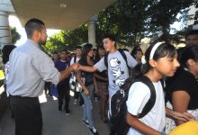 Teacher greets a student on the way into school